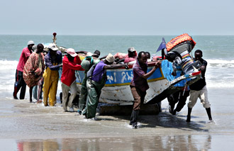 Samen duwen de vissers de boot het strand op - foto: Friedrich Stark