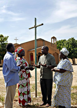 De pastoor praat met parochianen voor de kerk - Foto: Friedrich Stark
